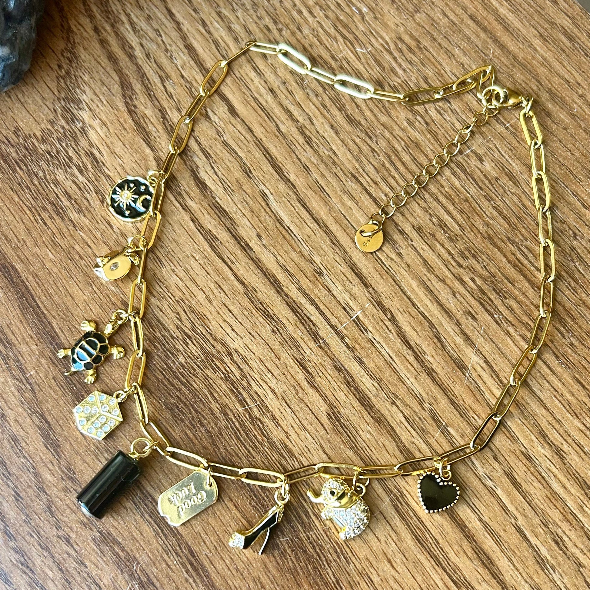 Gold necklace with charms on a wooden surface