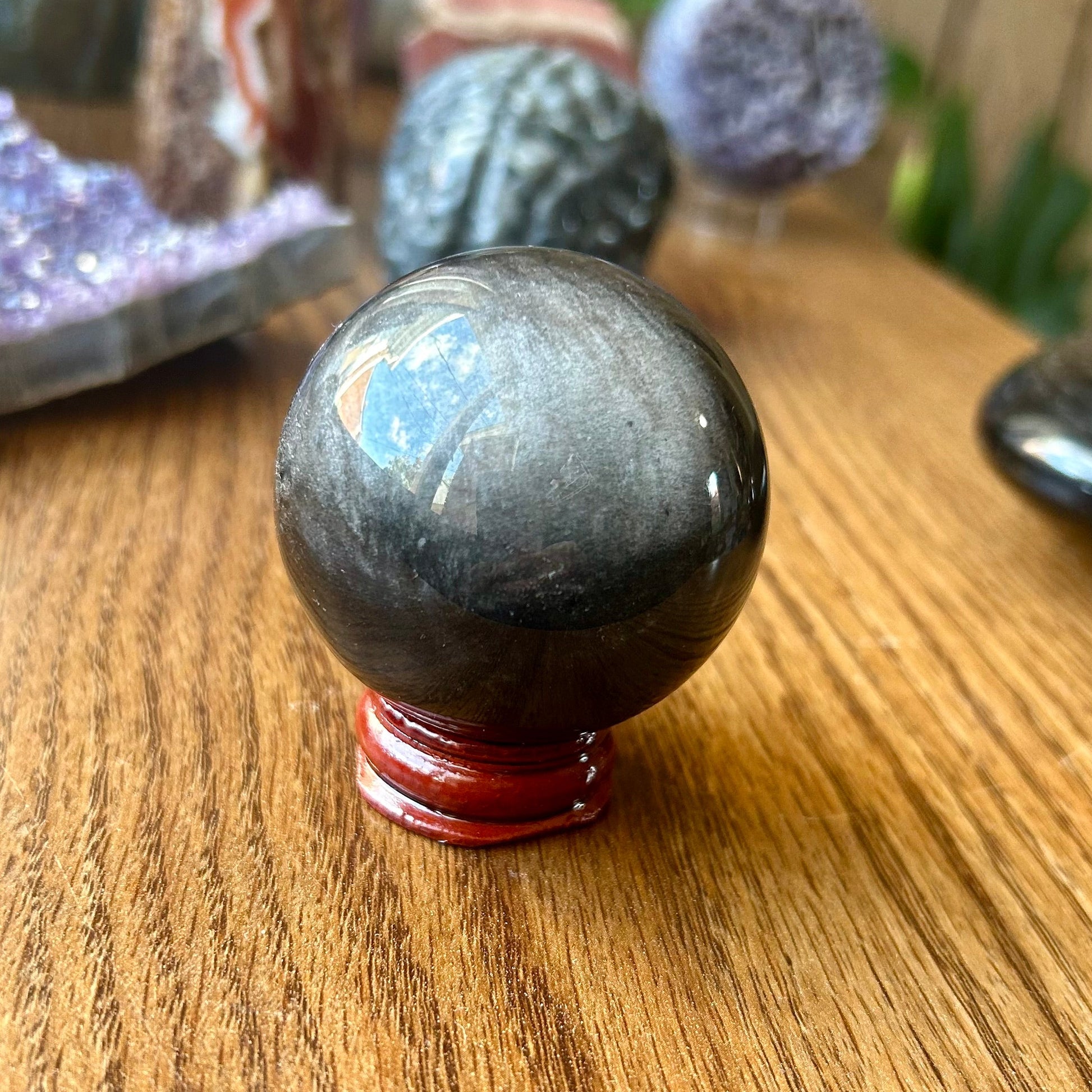 Black crystal ball on a wooden surface with blurred background