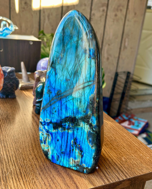 Blue and green crystal on a wooden surface with a blurred background