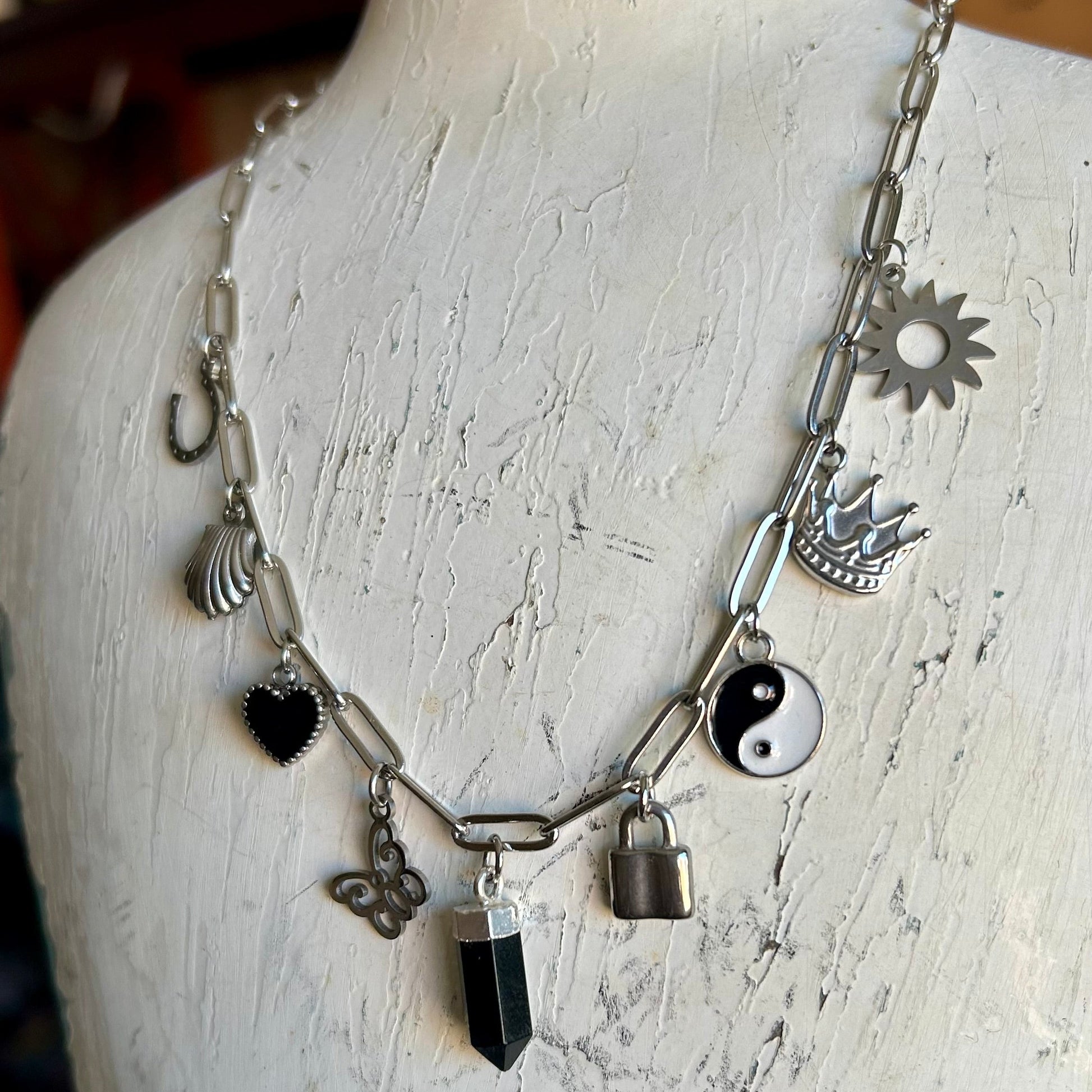 Necklace with various charms on a mannequin bust