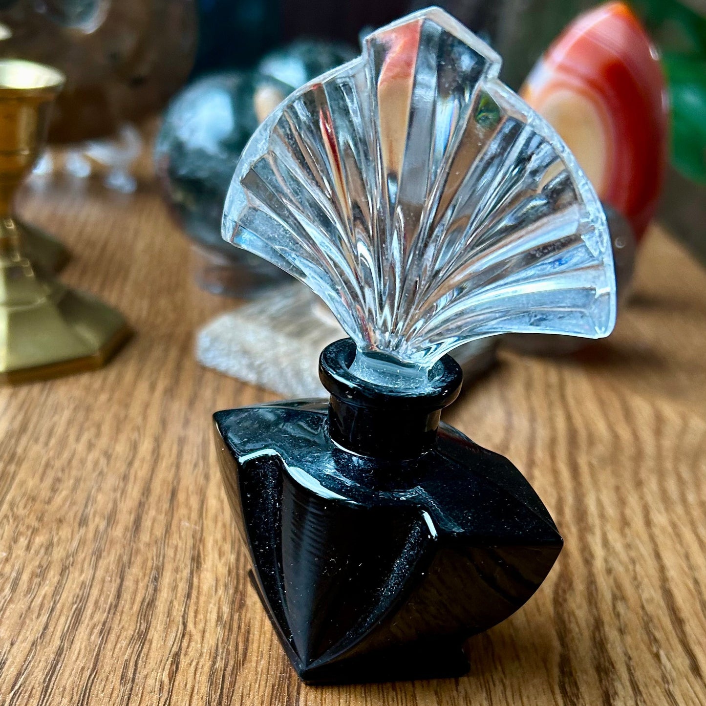 Decorative object with black base and clear fan-shaped top on a wooden surface