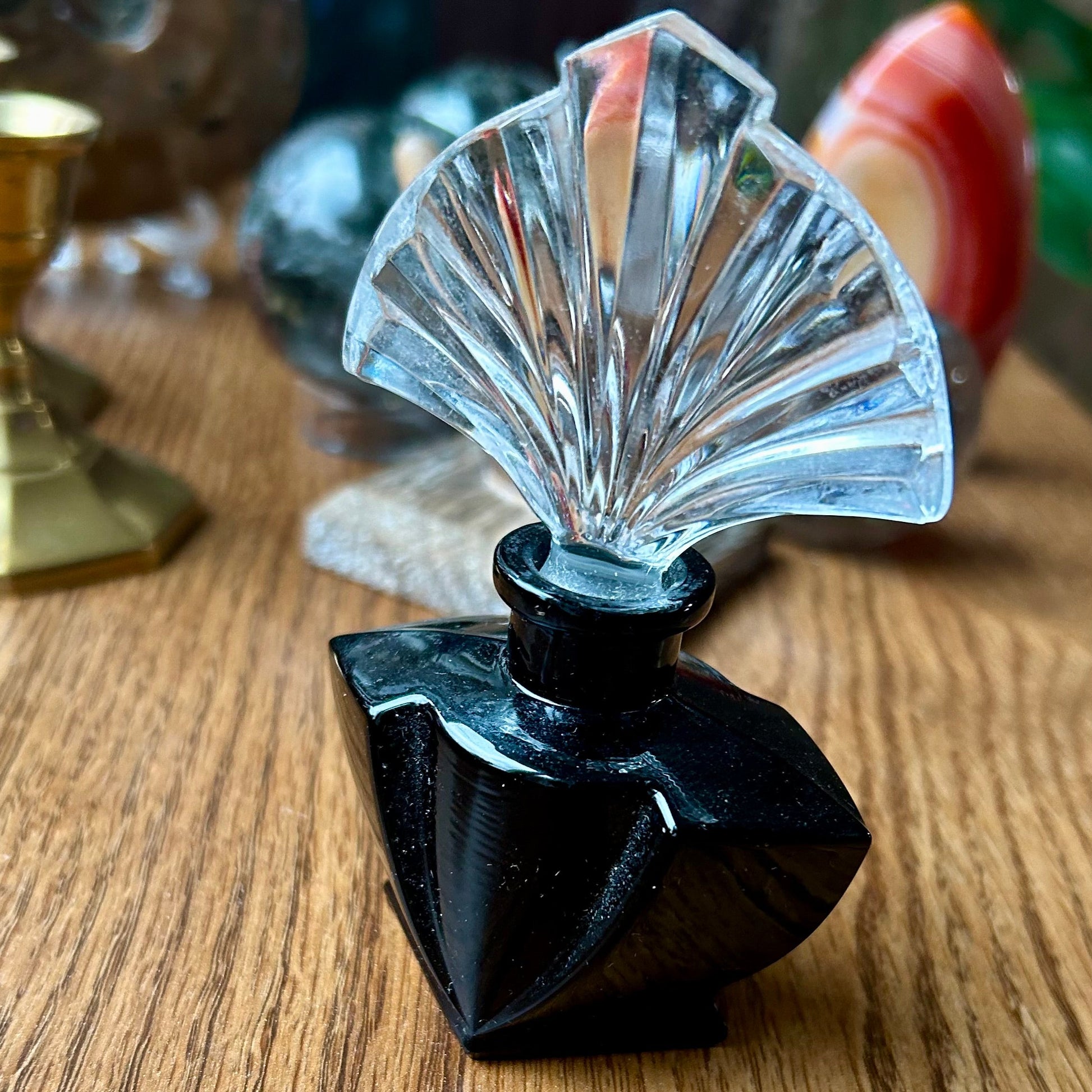 Decorative object with black base and clear fan-shaped top on a wooden surface