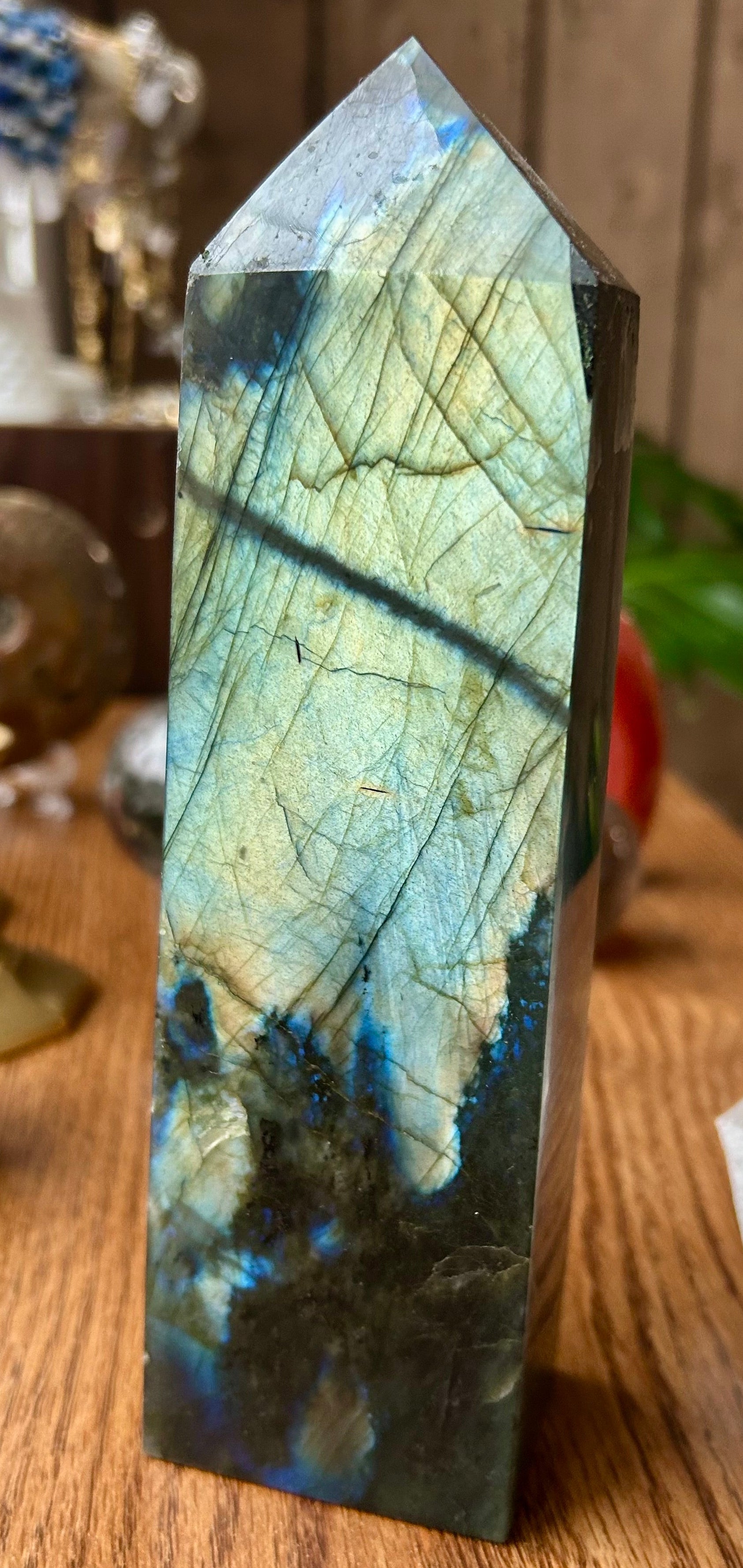 Labradorite crystal tower on a wooden surface with a blurred background