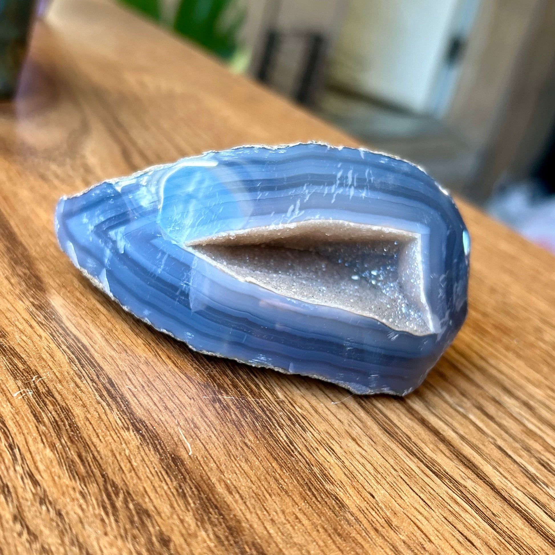 Blue crystal on a wooden surface with a blurred background