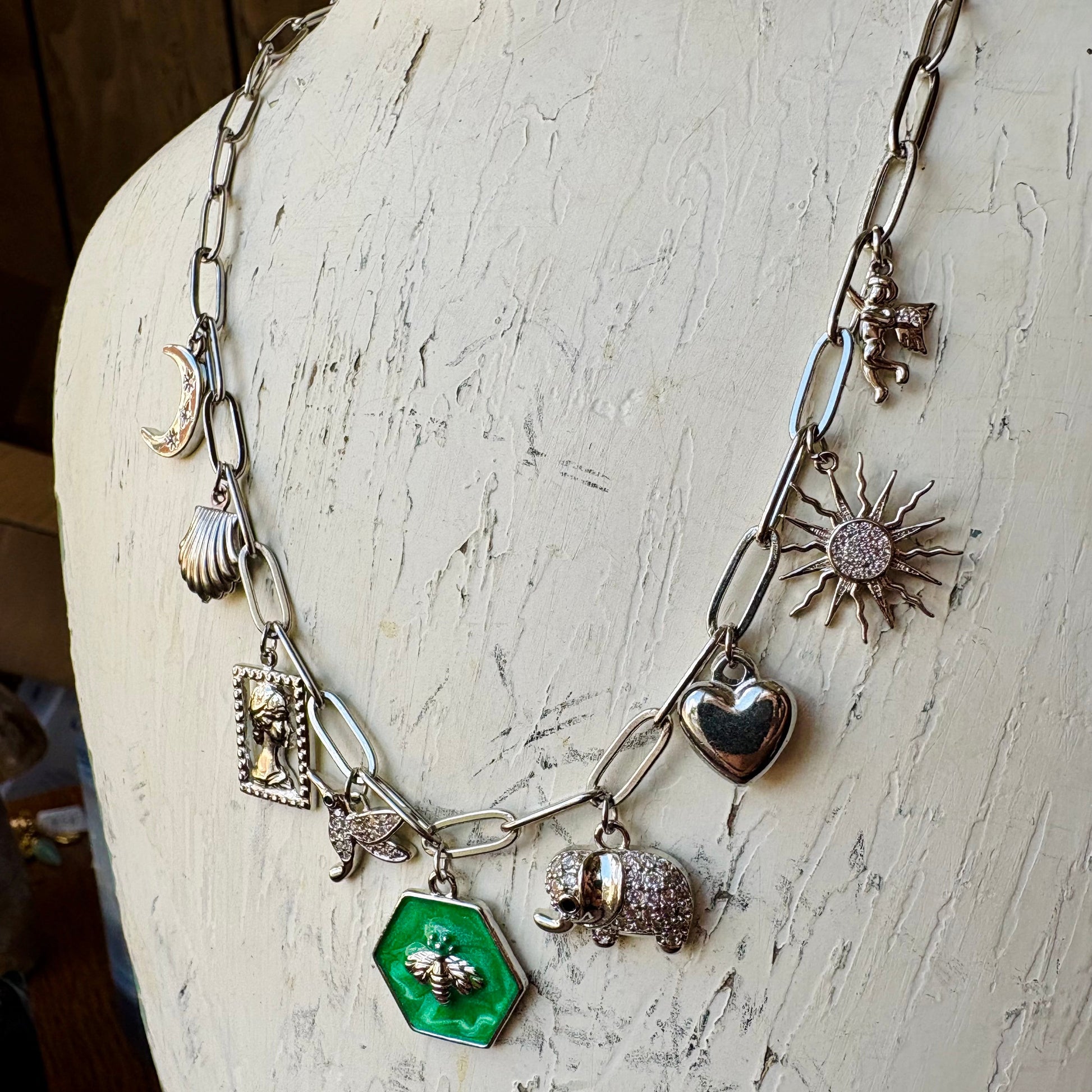 Necklace with various charms on a textured white surface