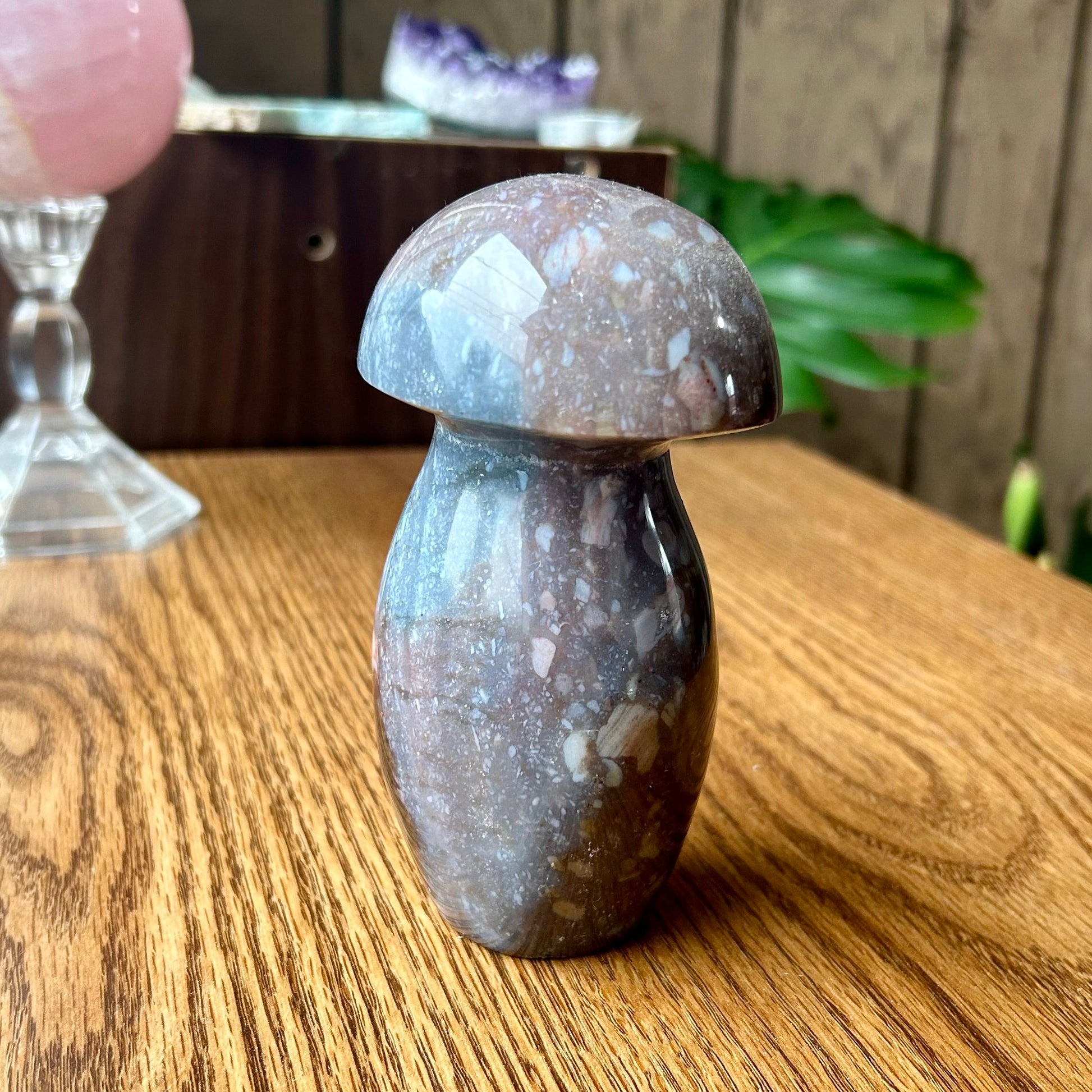 Decorative stone mushroom on a wooden surface with a blurred background