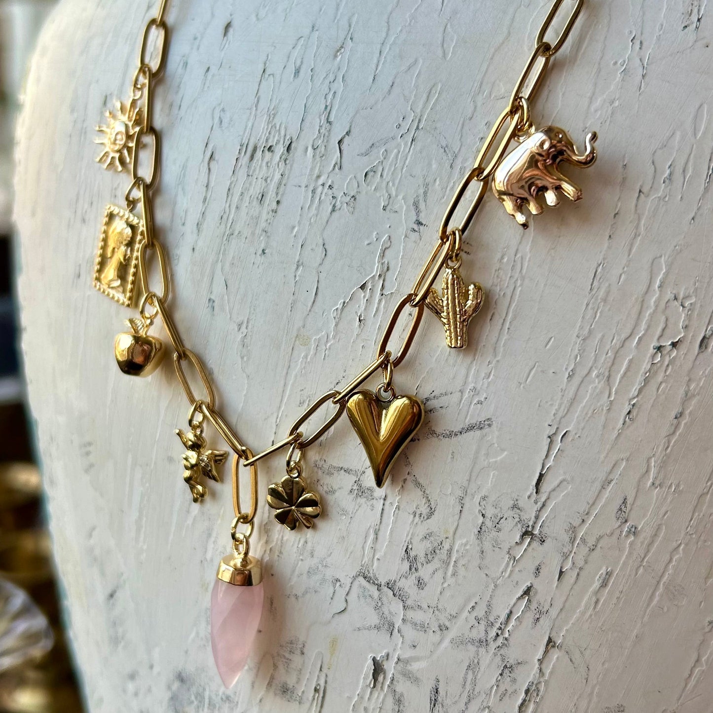 Gold necklace with charms on a mannequin bust
