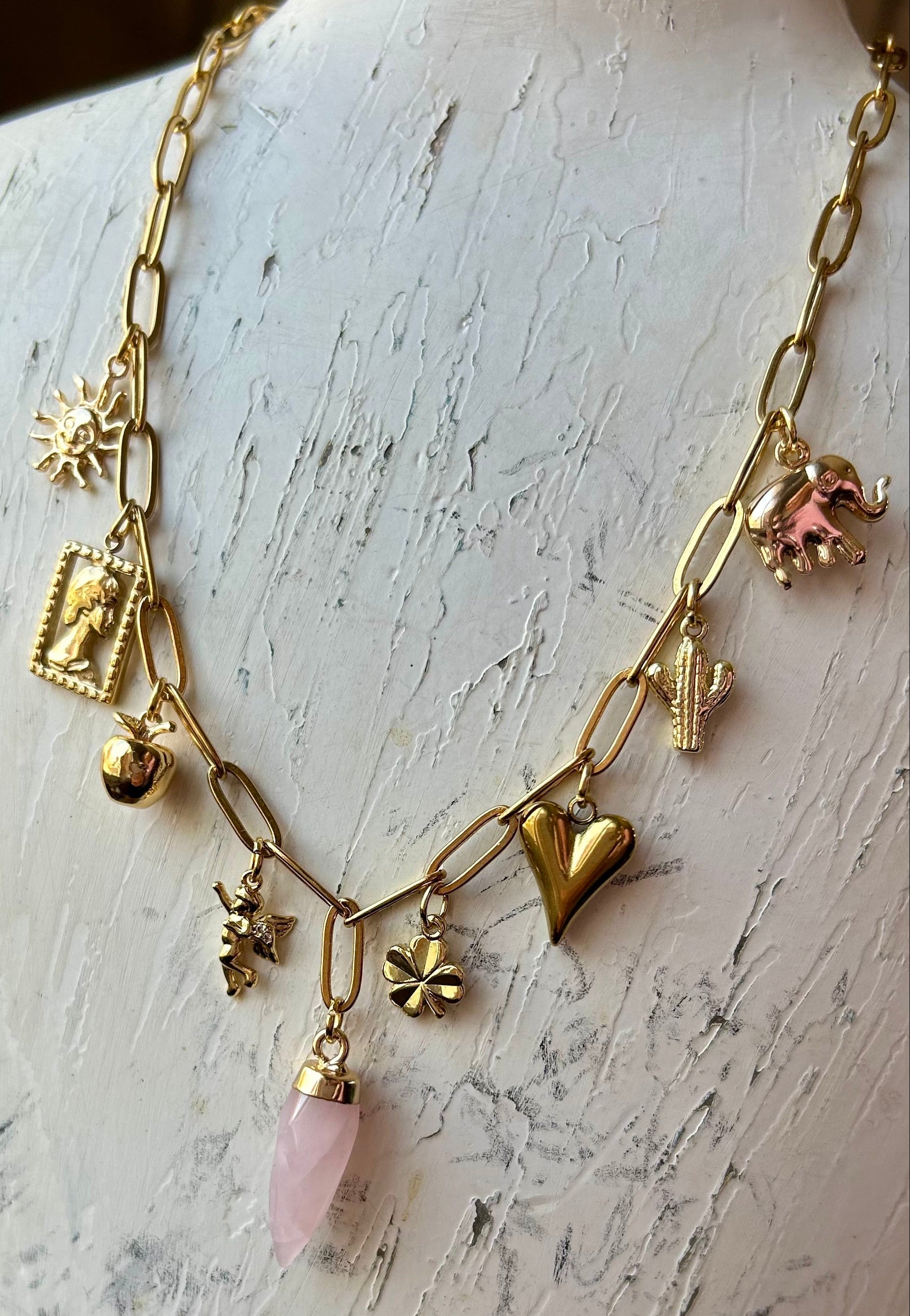 Gold necklace with charms on a mannequin bust