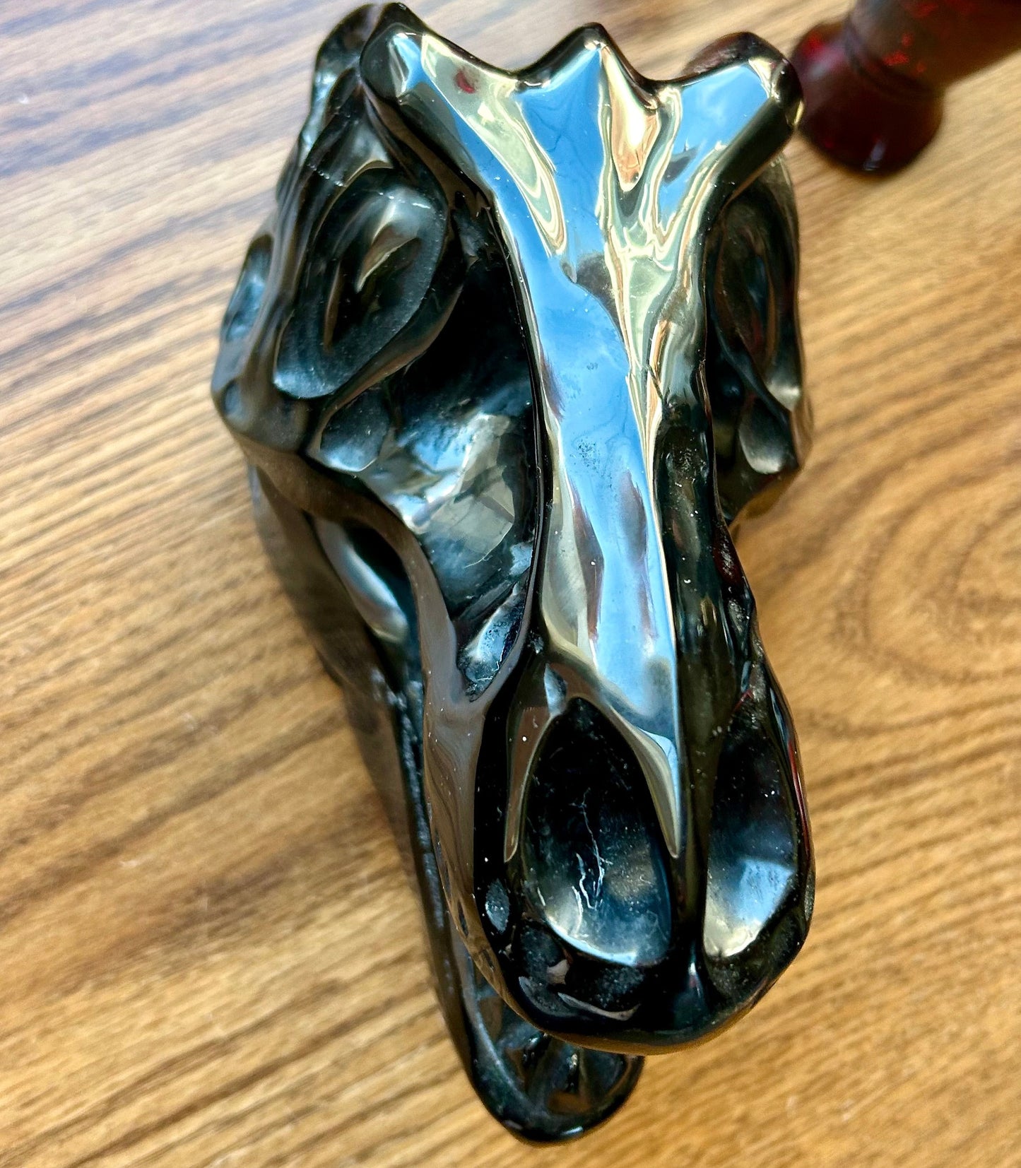 Decorative metal horse head sculpture on a wooden surface