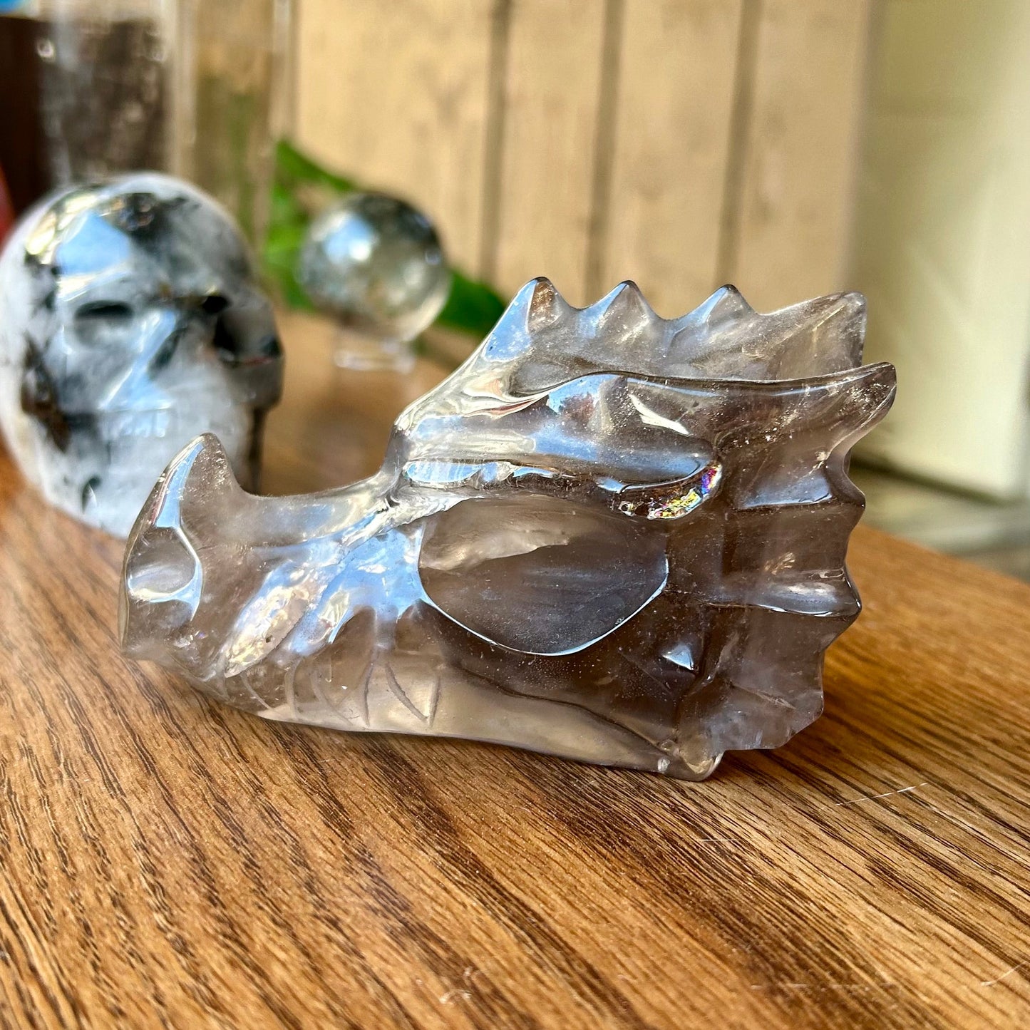 Crystal dragon sculpture on a wooden surface with blurred background