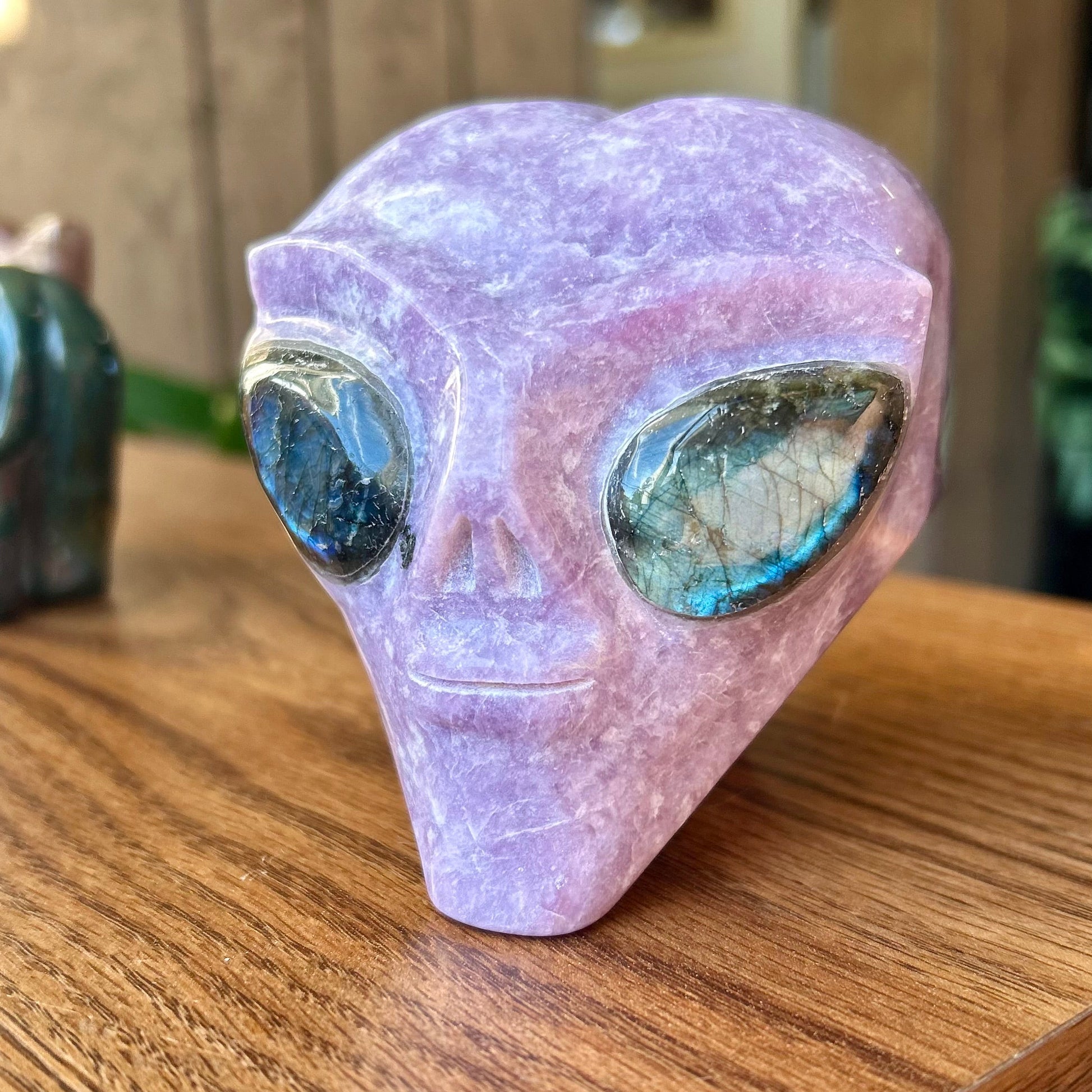 Crystal alien head on a wooden surface with a blurred background