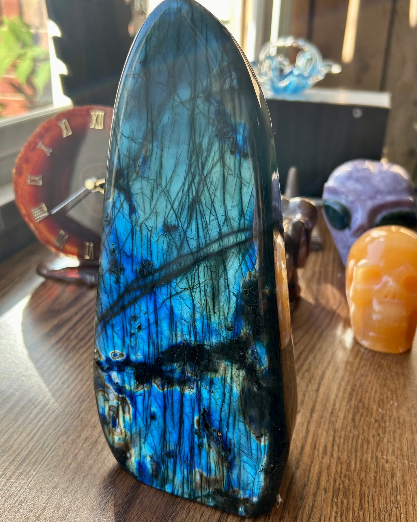 Blue and black crystal on a wooden surface with blurred background