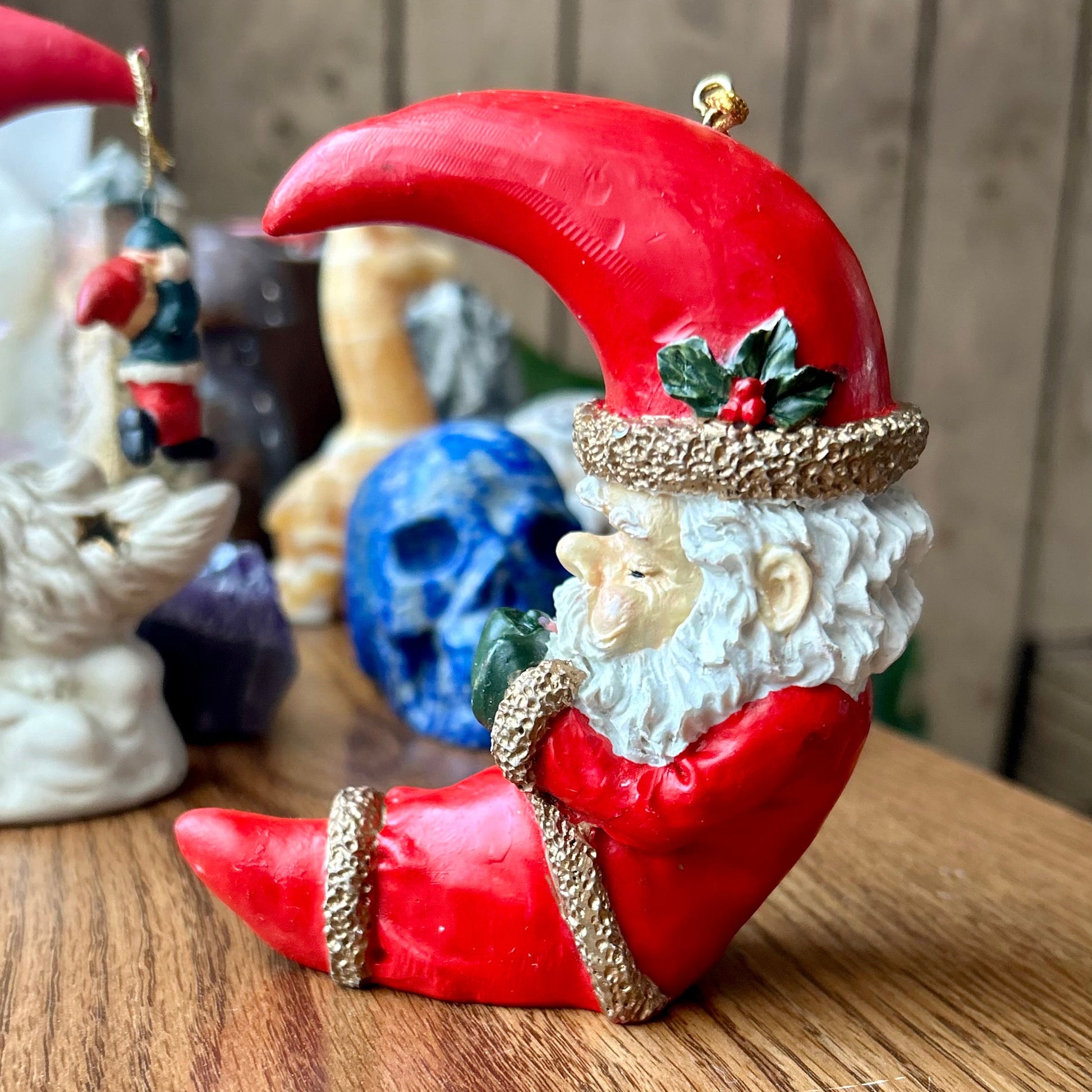 Decorative Santa Claus figure with a red beard on a wooden surface