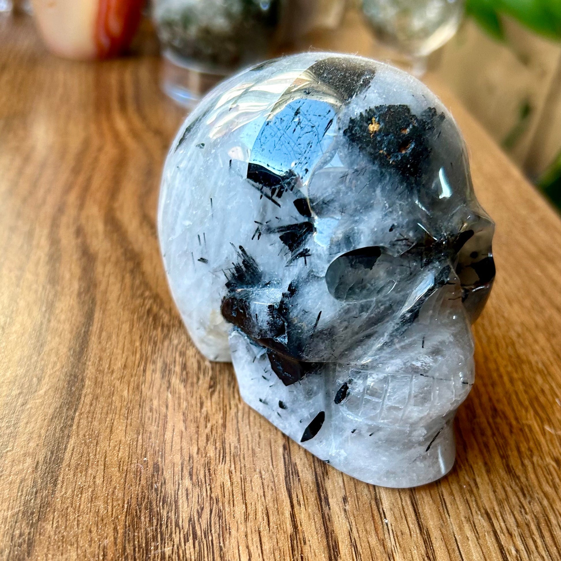 Crystal rock with black and blue mineral inclusions on a wooden surface