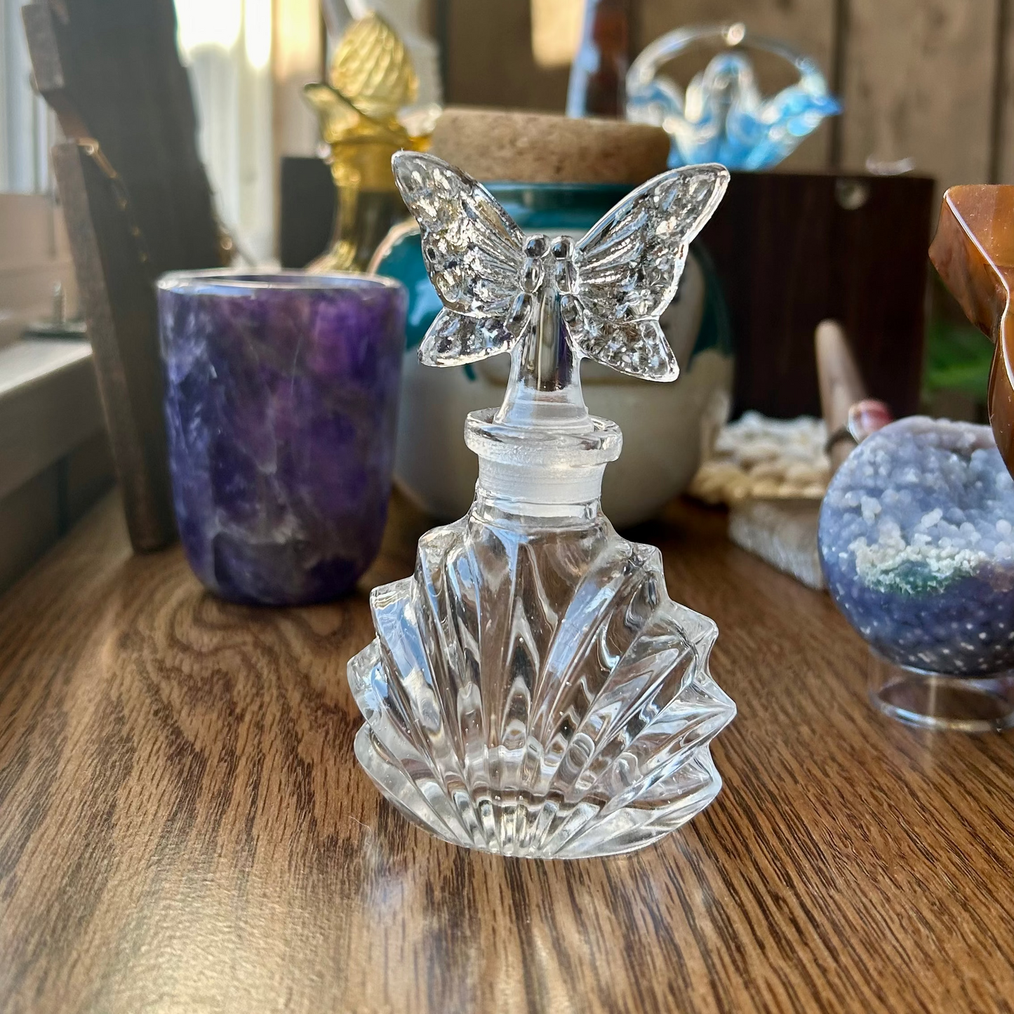Crystal butterfly bottle on a wooden surface with blurred background