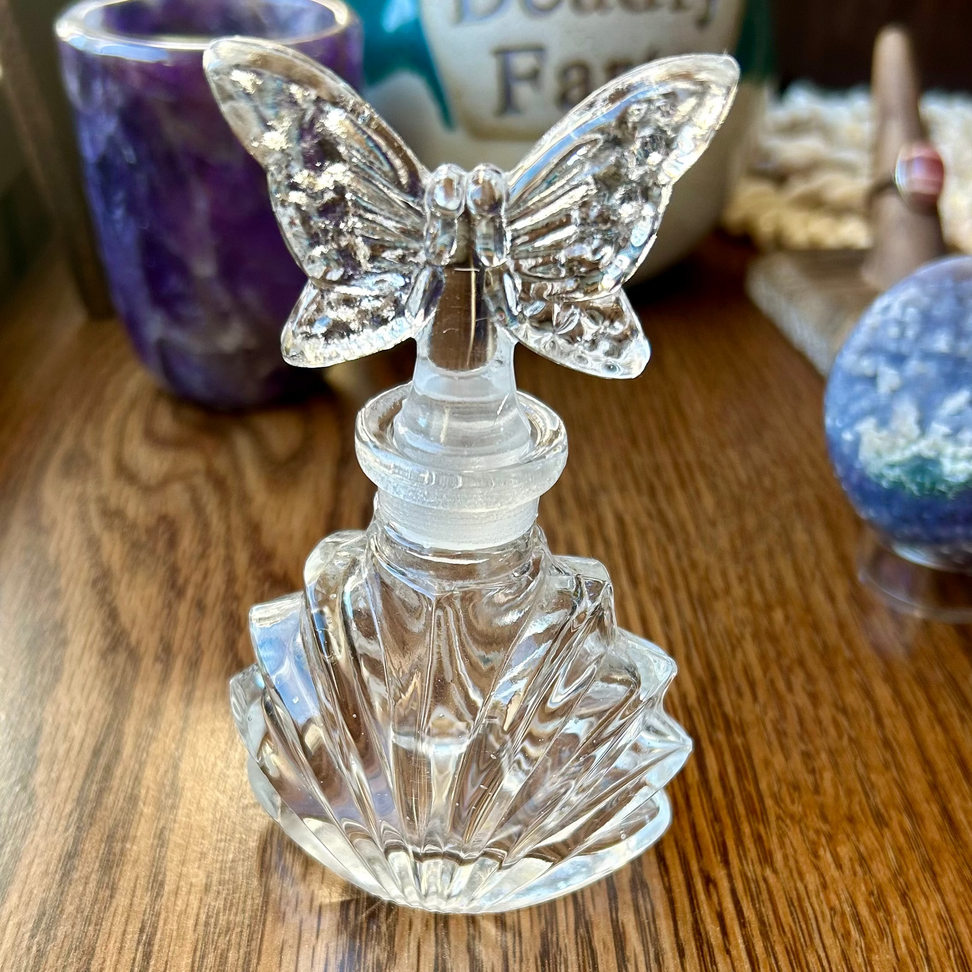 Crystal butterfly bottle stopper on a wooden surface with a blurred background